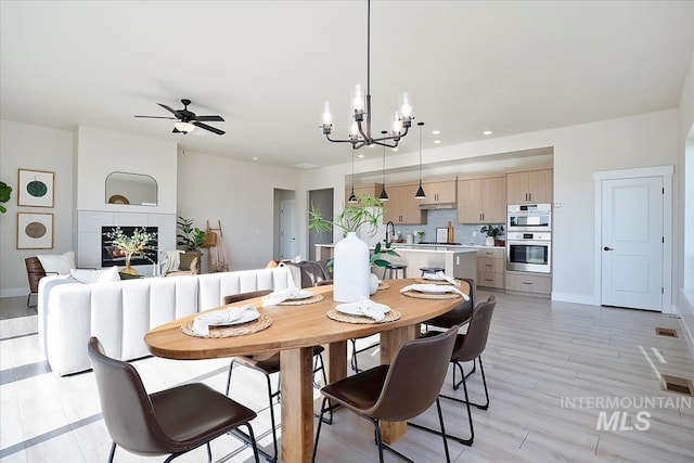 6200 S Binky Ave, Meridian, ID 83642 - dining space with a chandelier, recessed lighting, a ceiling fan, baseboards, and a tiled fireplace