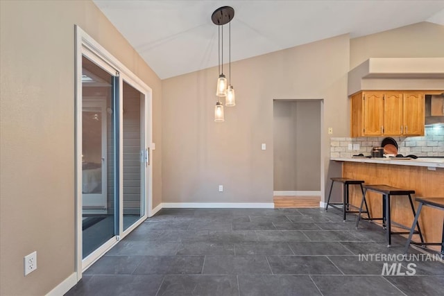 11909 W Patrina Dr, Boise, ID 83713 - kitchen with lofted ceiling, decorative backsplash, a breakfast bar, light countertops, and decorative light fixtures