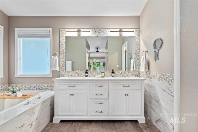 11909 W Patrina Dr, Boise, ID 83713 - bathroom featuring double vanity, a garden tub, wood finished floors, and tile walls