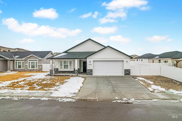 view of front of house with a garage, stone siding, fence, and driveway