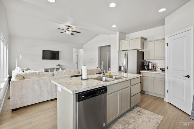 kitchen featuring tasteful backsplash, appliances with stainless steel finishes, light countertops, light wood-style floors, and a sink