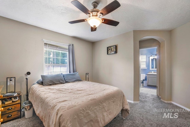 914 Aspenwood Ln, Twin Falls, ID 83301 - bedroom with arched walkways, multiple windows, light carpet, baseboards, and a textured ceiling