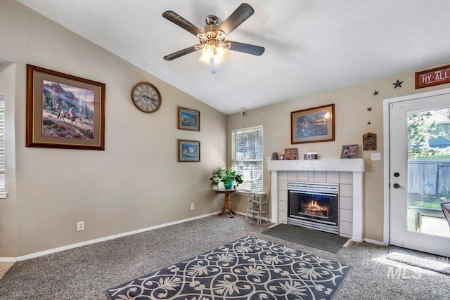 914 Aspenwood Ln, Twin Falls, ID 83301 - carpeted living room featuring a tiled fireplace, a ceiling fan, vaulted ceiling, baseboards, and a textured ceiling