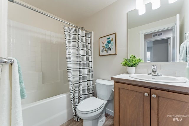 full bathroom with visible vents, shower / bath combo, wood finished floors, vanity, and toilet