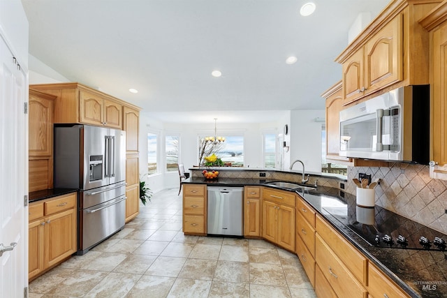 kitchen featuring sink, appliances with stainless steel finishes, decorative light fixtures, kitchen peninsula, and a chandelier