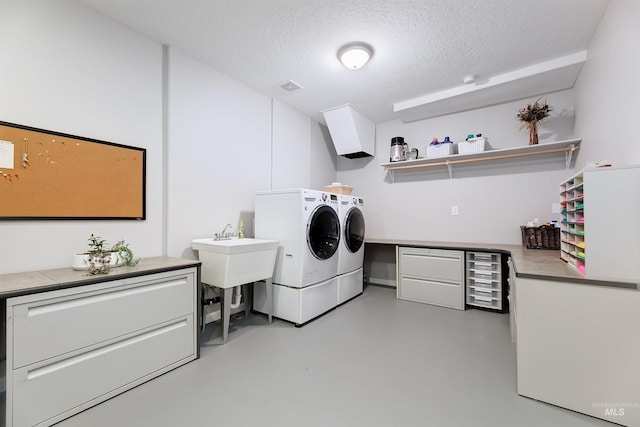 washroom featuring cabinets, washer and dryer, and a textured ceiling