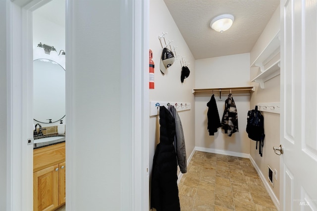 interior space with a textured ceiling and sink