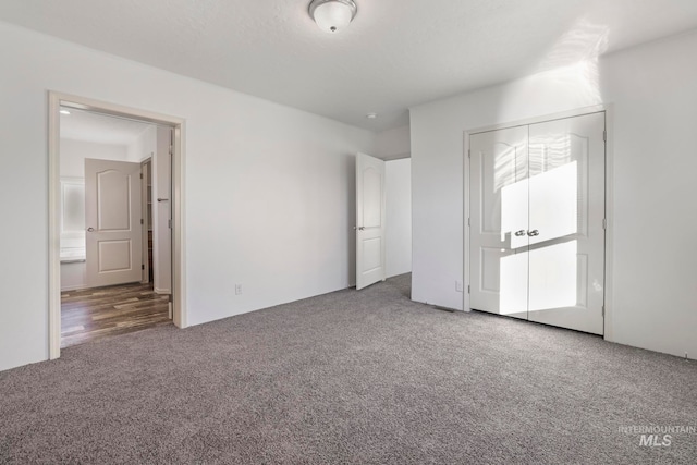 unfurnished bedroom featuring carpet flooring and a closet