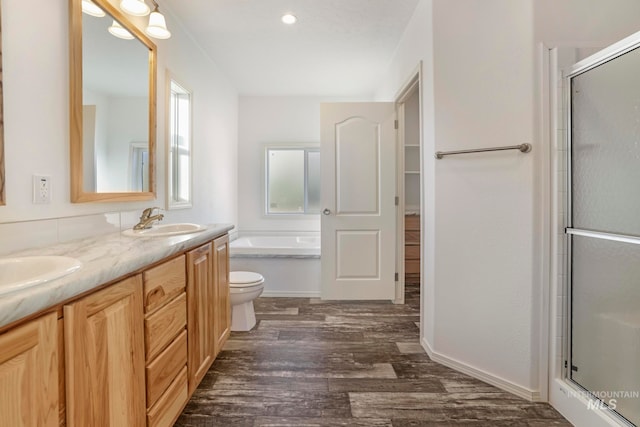 full bathroom with toilet, hardwood / wood-style floors, vanity, and shower with separate bathtub