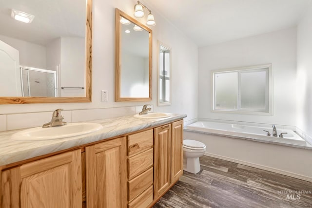 full bathroom featuring hardwood / wood-style floors, vanity, toilet, and independent shower and bath