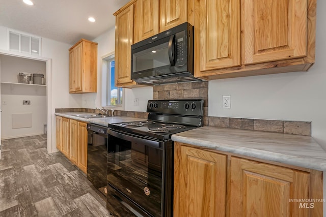 kitchen featuring sink, dark wood-type flooring, and black appliances