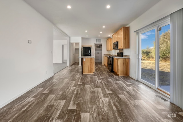 kitchen featuring a center island, black appliances, and dark hardwood / wood-style floors