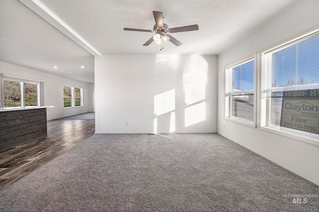 empty room featuring a textured ceiling, ceiling fan, and dark hardwood / wood-style floors