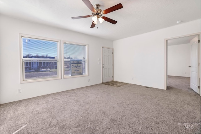 empty room featuring ceiling fan and carpet floors