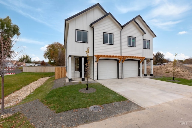 view of front of house featuring board and batten siding, a front lawn, fence, concrete driveway, and a garage