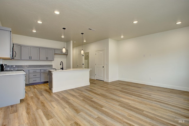 kitchen with a sink, range with electric stovetop, light wood-style flooring, and gray cabinets