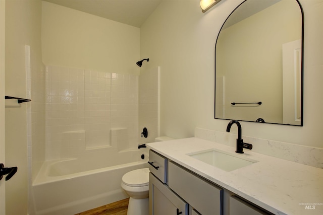 bathroom with tub / shower combination, toilet, wood finished floors, and vanity