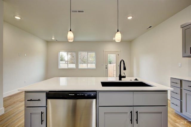 kitchen with visible vents, gray cabinets, stainless steel dishwasher, light wood-style floors, and a sink