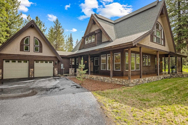 14199 Franklin Rd, Mccall, ID 83638 - view of front of house featuring a porch, asphalt driveway, a shingled roof, a garage, and a front lawn
