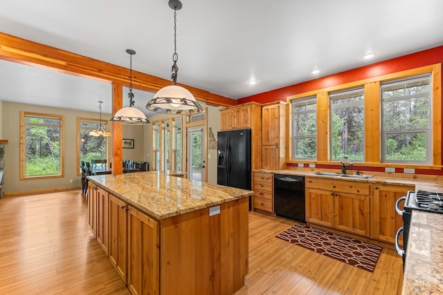 14199 Franklin Rd, Mccall, ID 83638 - kitchen with black appliances, a kitchen island, light wood-style floors, light stone countertops, and decorative light fixtures