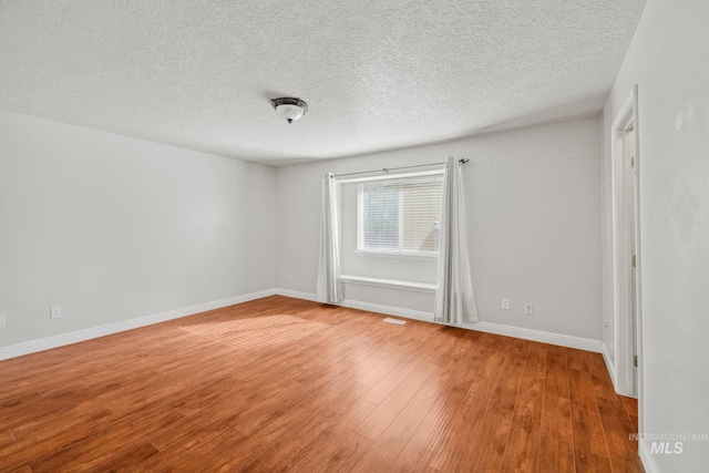 5101 Barkley Way, Caldwell, ID 83607 - unfurnished room featuring wood finished floors, baseboards, and a textured ceiling