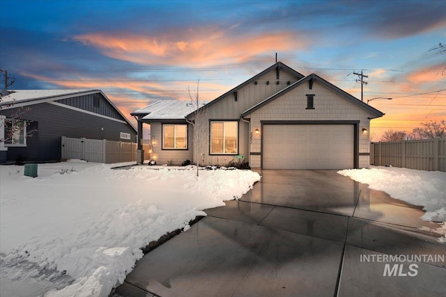 view of front of property featuring driveway, an attached garage, fence, and board and batten siding