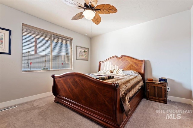 bedroom featuring visible vents, baseboards, light colored carpet, and ceiling fan