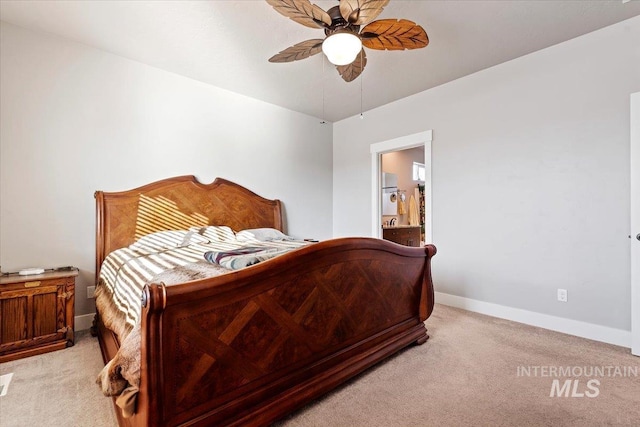 bedroom featuring light carpet, ceiling fan, ensuite bathroom, and baseboards