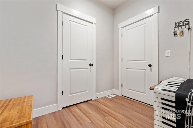 interior space featuring light wood finished floors and baseboards