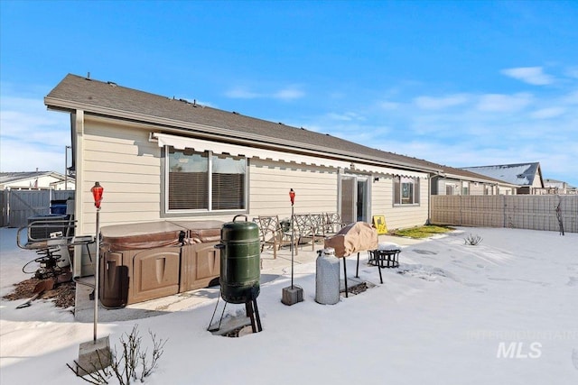 rear view of house featuring a patio, a hot tub, and a fenced backyard