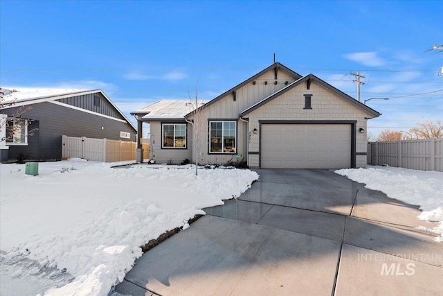 view of front of house featuring board and batten siding, concrete driveway, an attached garage, and fence