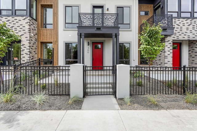 view of exterior entry featuring a balcony