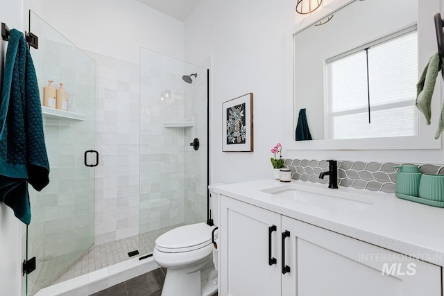 bathroom with vanity, tile patterned floors, toilet, and a stall shower