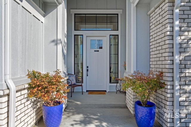 doorway to property featuring brick siding