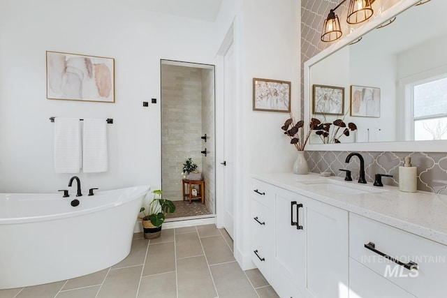 full bathroom with vanity, tiled shower, a freestanding tub, decorative backsplash, and tile patterned flooring