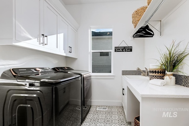 laundry area featuring visible vents, baseboards, washer and dryer, cabinet space, and a sink