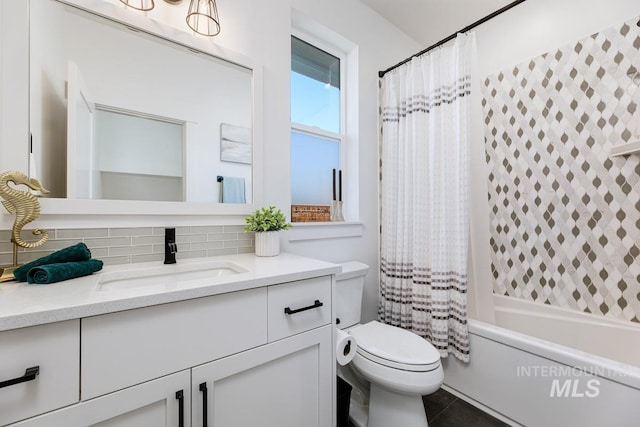 full bath featuring vanity, shower / bath combo, tile patterned floors, toilet, and tasteful backsplash