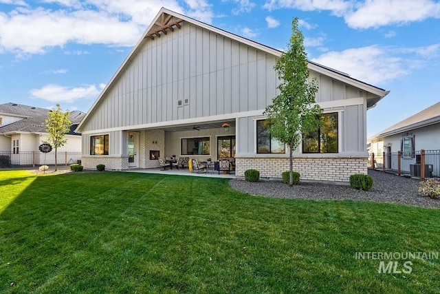 back of property featuring a patio area, fence, board and batten siding, and a lawn