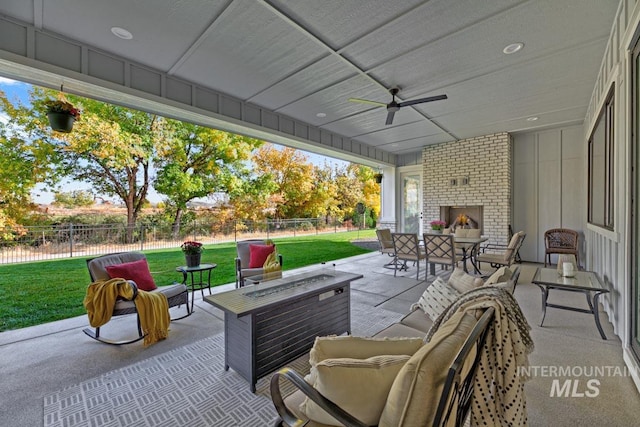 view of patio / terrace featuring an outdoor living space with a fireplace, a ceiling fan, and fence