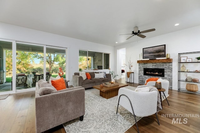 living room with recessed lighting, a ceiling fan, wood finished floors, and a fireplace