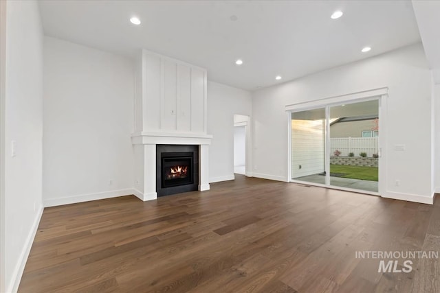 unfurnished living room featuring dark hardwood / wood-style floors and a fireplace