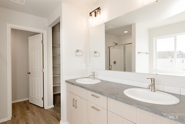 bathroom with a shower with door, vanity, and hardwood / wood-style flooring