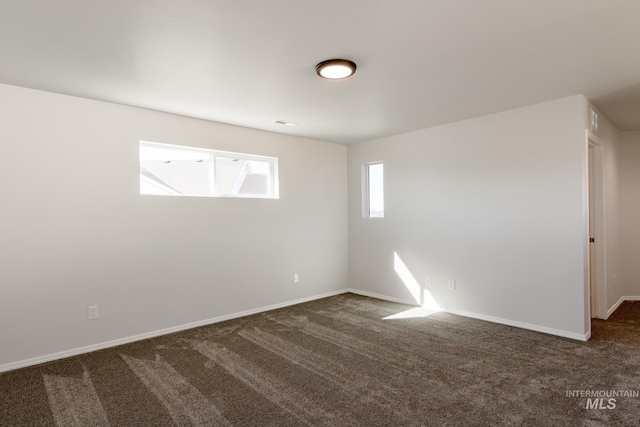 unfurnished room with dark colored carpet