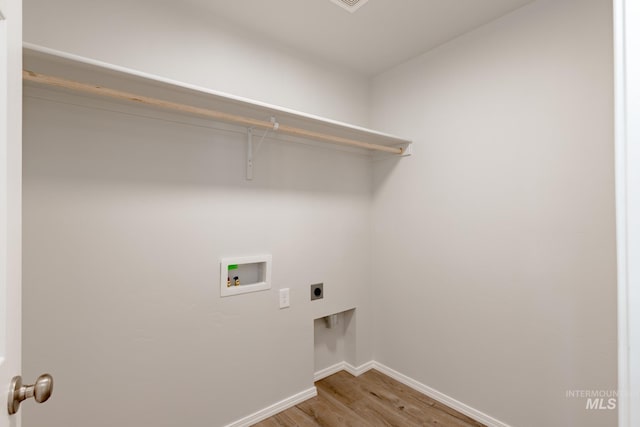 clothes washing area with electric dryer hookup, washer hookup, and light hardwood / wood-style floors