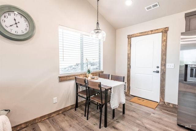 dining space featuring lofted ceiling and light wood-type flooring