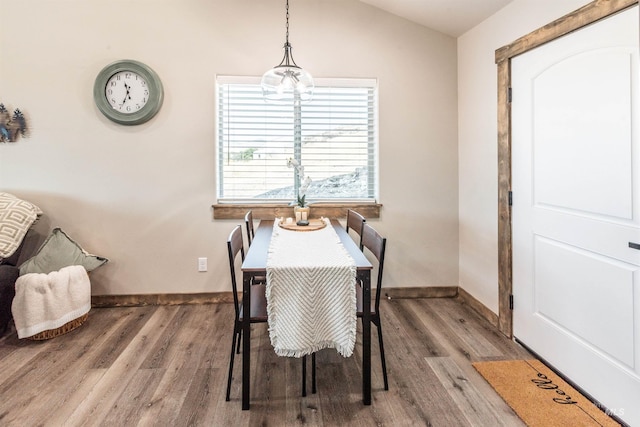 dining room featuring hardwood / wood-style flooring and vaulted ceiling