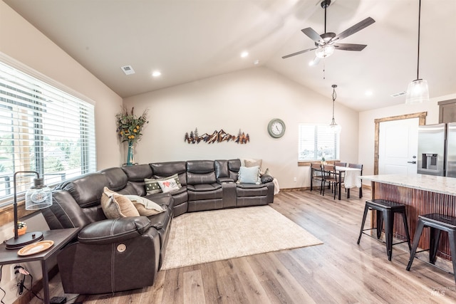 living room featuring ceiling fan, light hardwood / wood-style floors, and lofted ceiling