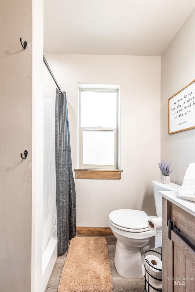 bathroom featuring vanity, hardwood / wood-style flooring, toilet, and walk in shower