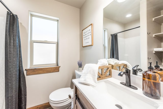 bathroom with a shower with shower curtain, vanity, and toilet