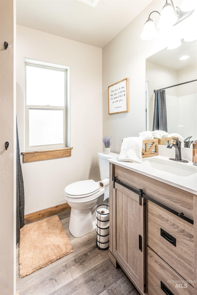 bathroom with vanity, hardwood / wood-style flooring, an inviting chandelier, toilet, and curtained shower